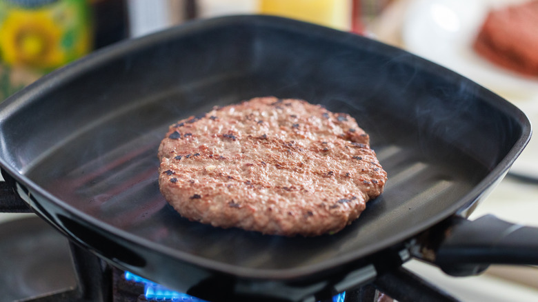 Burger patty in frying pan