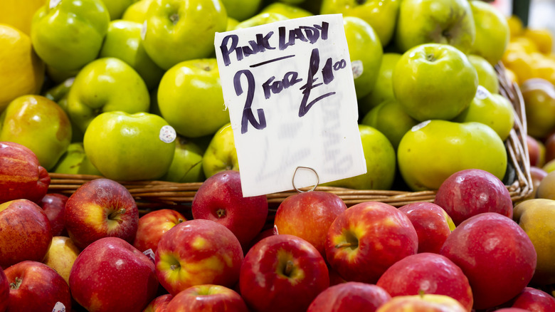 Green and Pink Lady apples at market