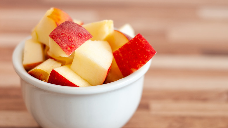 Diced red apples in small white bowl