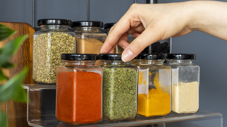 person choosing spices from rack