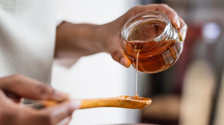 pouring smooth honey onto spoon