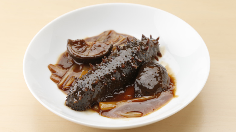 cooked sea cucumber on a plate with sauce