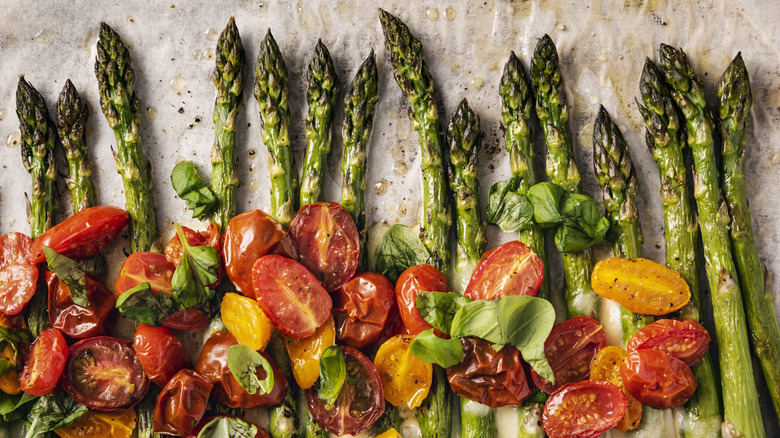 Cooked asparagus on with colorful cherry tomatoes