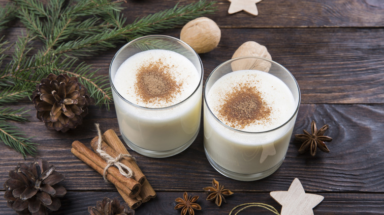 A glass of eggnog with spices in a festive setting