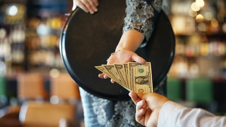 Person handing a server cash