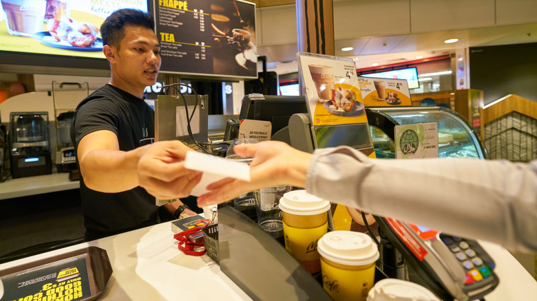 Employee handing receipt to customer