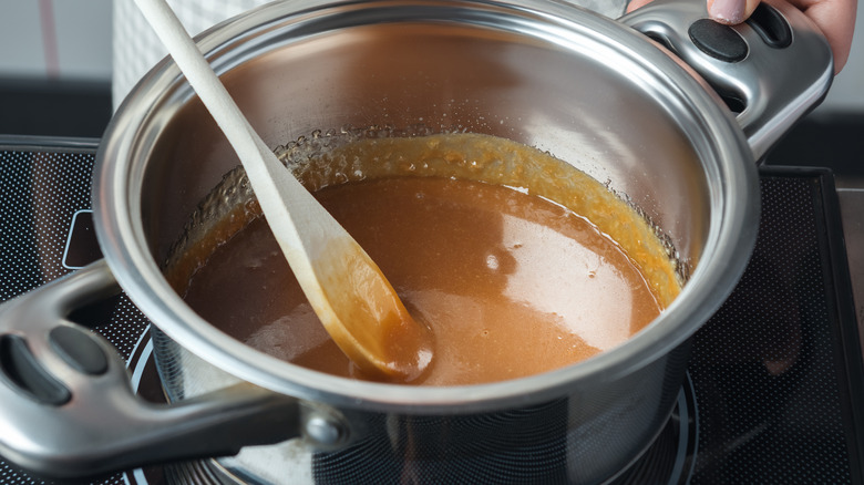 stirring caramel sauce on stove