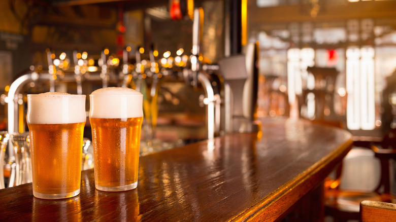 two glasses of beer at a bar