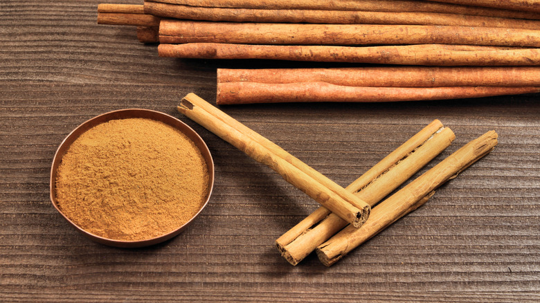 Cinnamon sticks and powder against a brown background