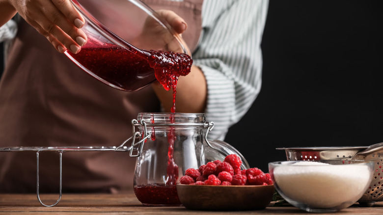 Person pouring jam into a jar