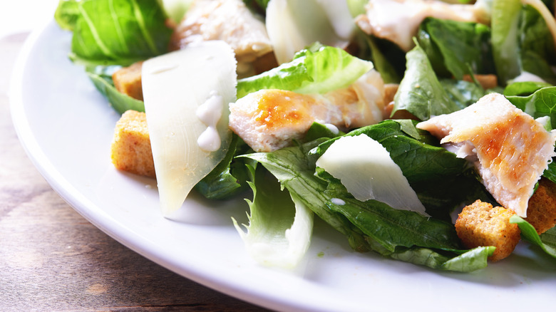 Caesar salad with chicken served in shallow bowl