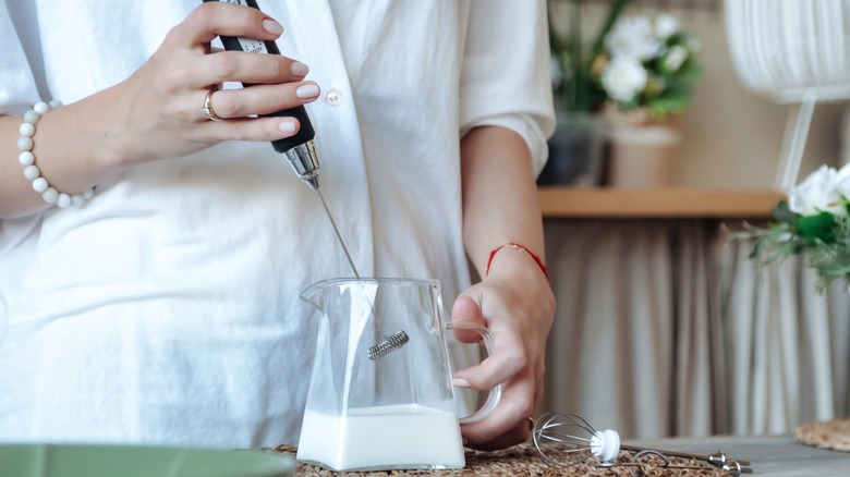 Woman using milk frother