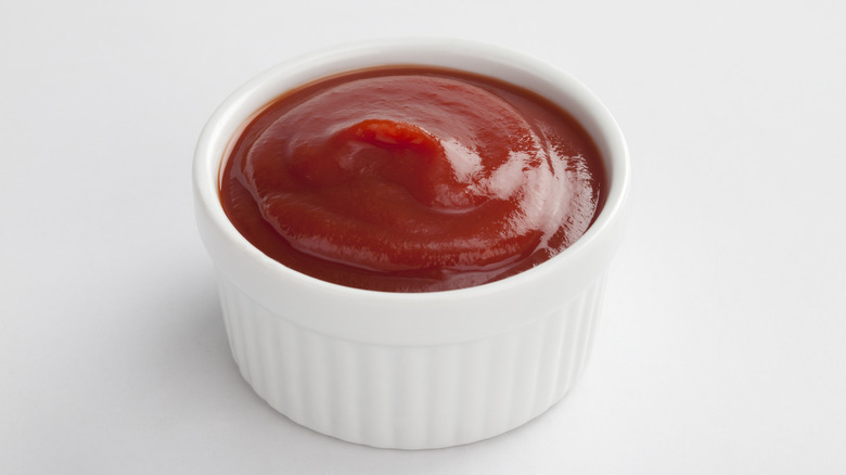 A small white bowl of ketchup