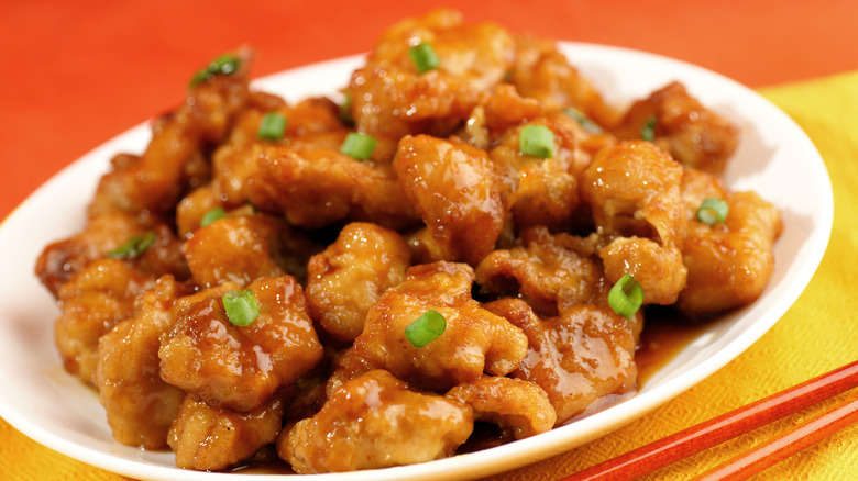 orange chicken on a white plate close up