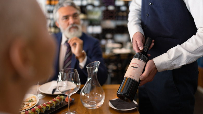 Close-up on a sommelier serving wine.