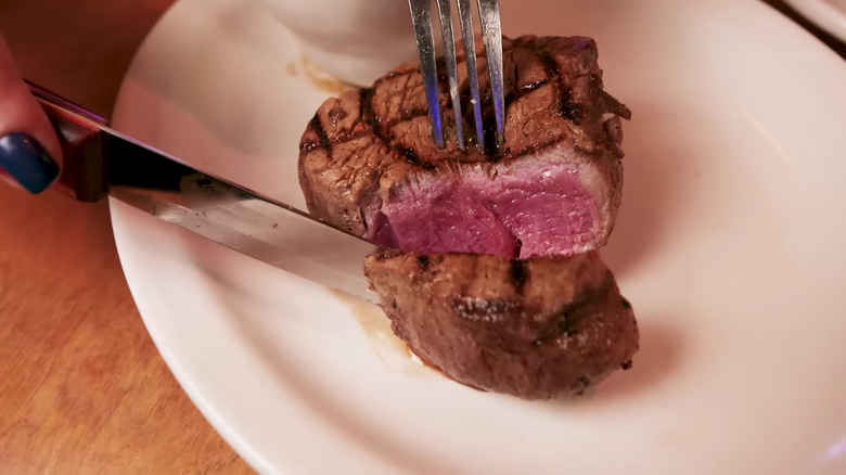 Fork and knife cutting steak