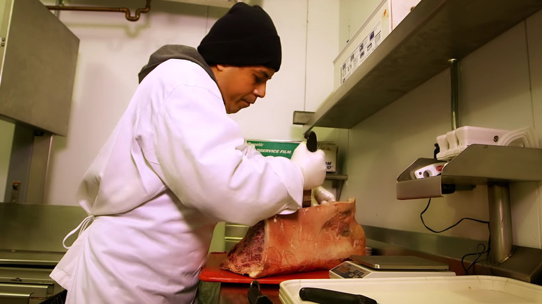 Worker cutting steaks at Capital Grille