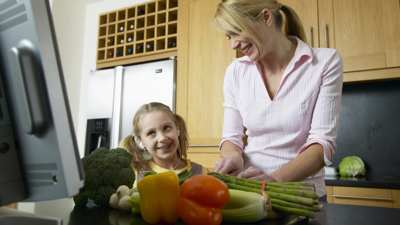 Mother and daughter chopping vegetables