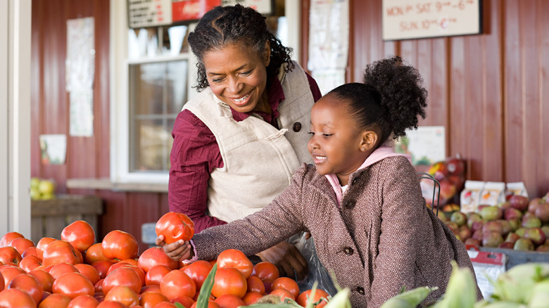 Mother and daughter selecting tomatoes