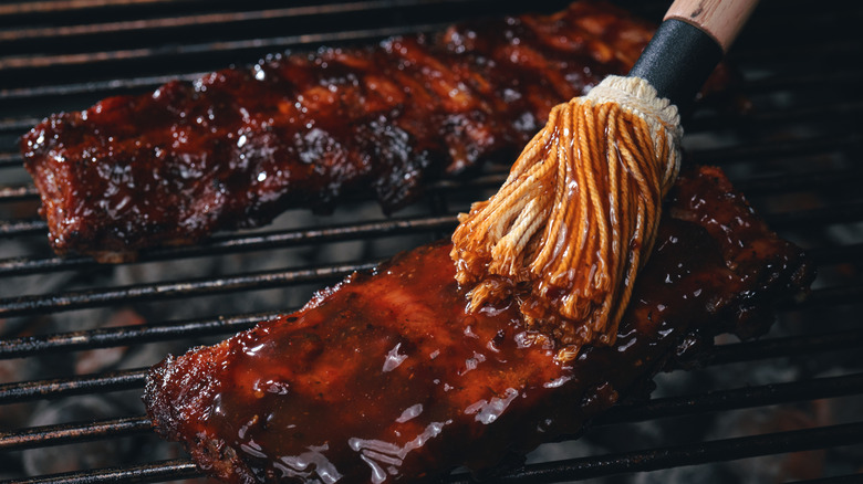 Brushing ribs with barbecue sauce