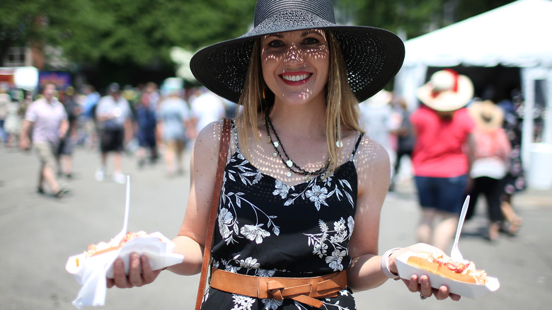 Woman holding two lobster rolls
