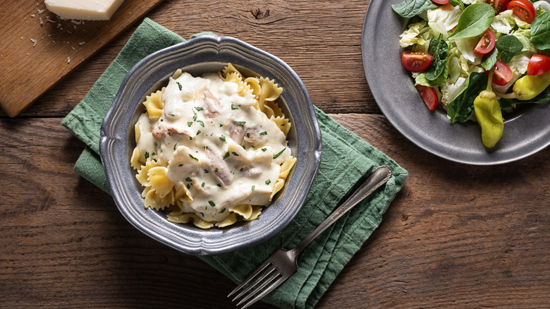 plate of pasta next to salad