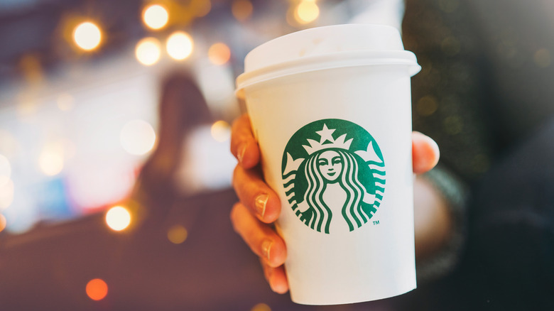 woman holding starbucks drink