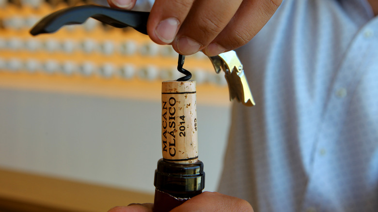 opening wine with corkscrew