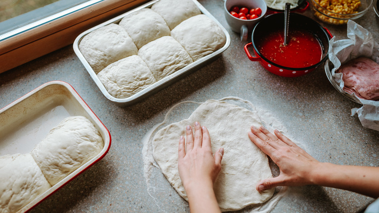 A person stretching out pizza dough