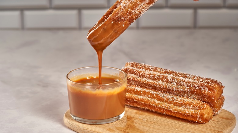 Churros dipped in caramel sauce