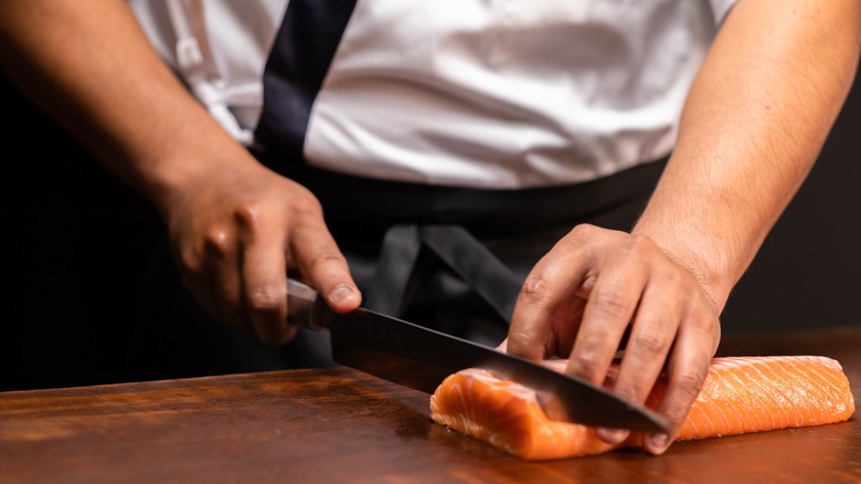 chef slicing raw salmon