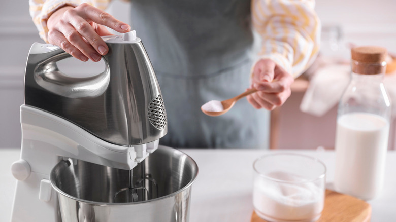 woman adding sugar to bowl