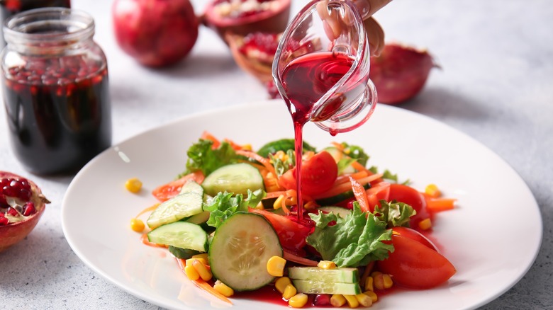 Pouring pomegranate molasses on salad