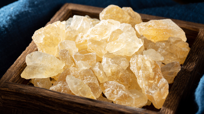 A wooden dish full of yellow rock sugar