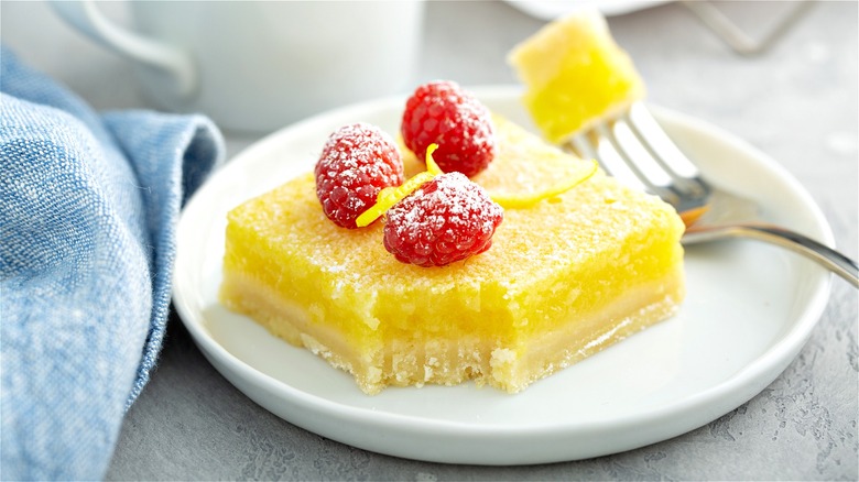 Lemon bar with raspberries on plate