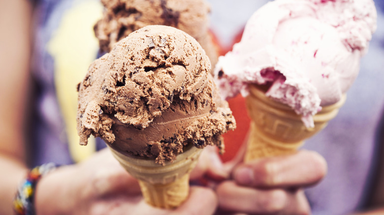 Chocolate and strawberry flavored ice creams in cones.