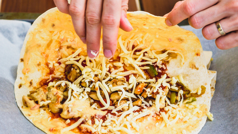 Person adding fillings to a quesadilla