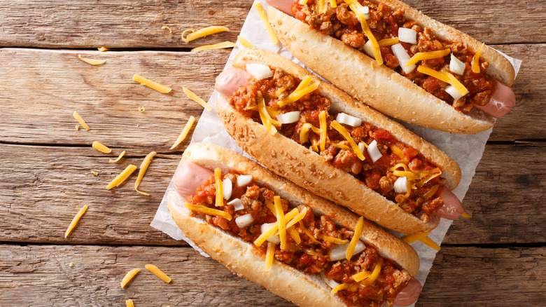 Three hot dogs with chili sauce