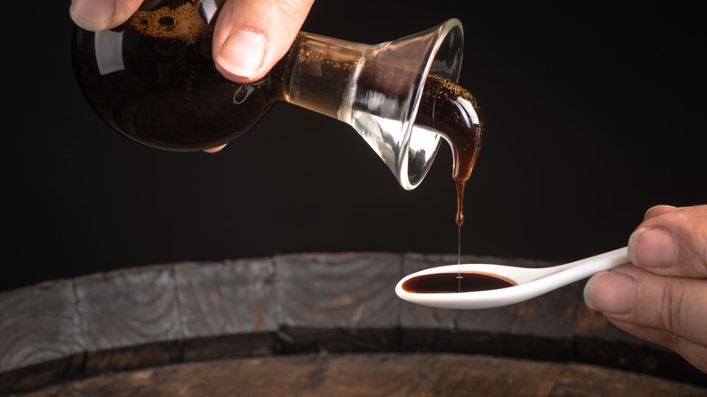 Balsamic vinegar being poured onto a spoon with barrel