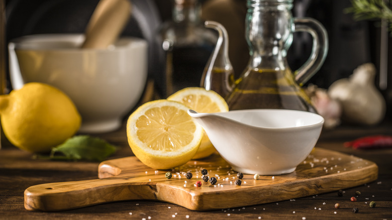 Lemons on cutting board with salad dressing