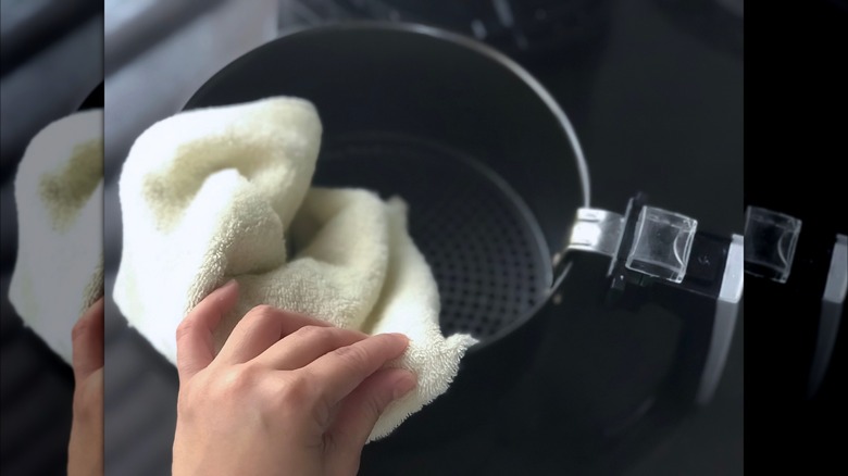 Person cleaning air fryer