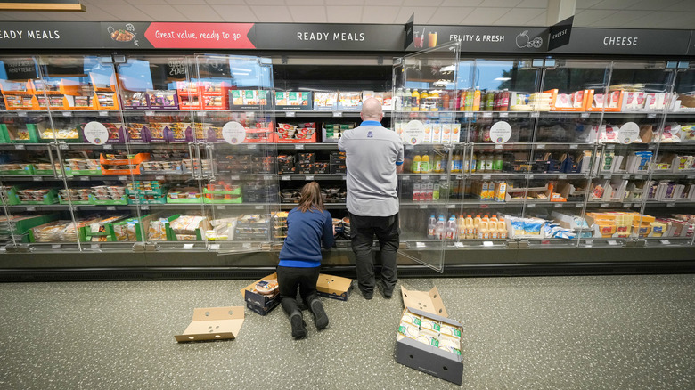 Employees stocking supermarket inventory