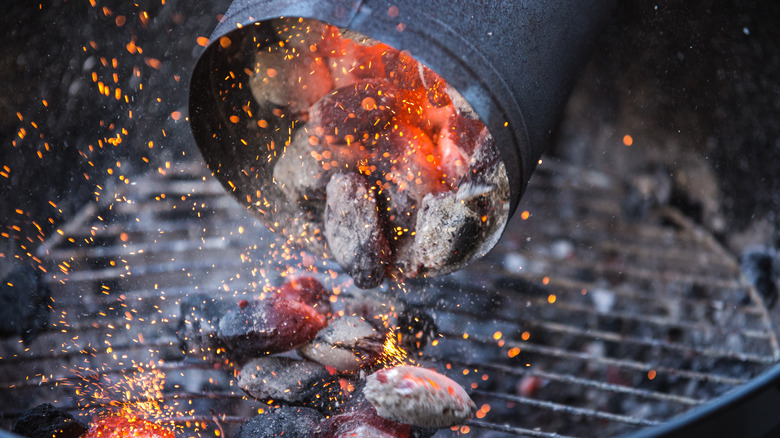 dumping lit charcoal into a grill