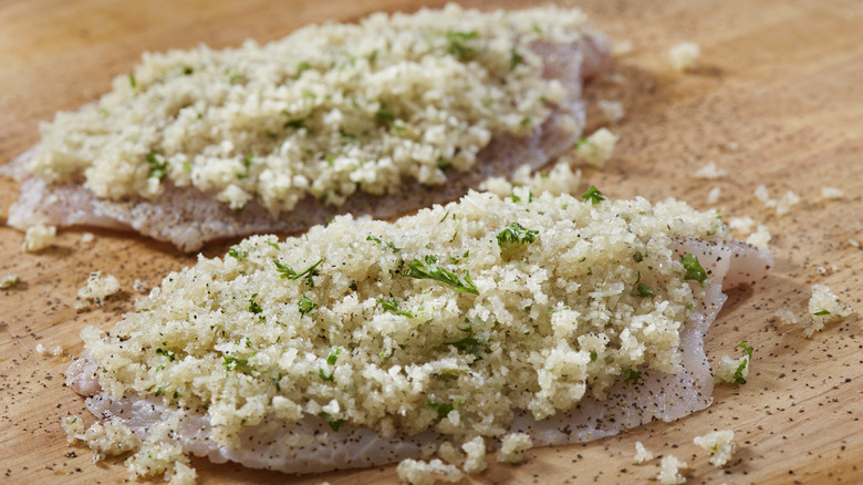 Seasoned breadcrumbs coating raw chicken