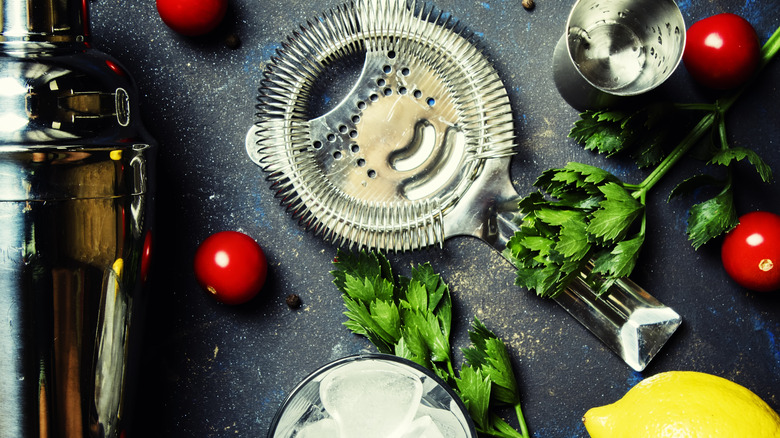 Cocktail shaker with tomatoes, parsley, lemon