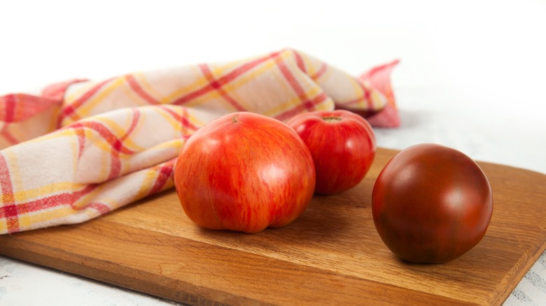 towel and tomatoes on cutting board