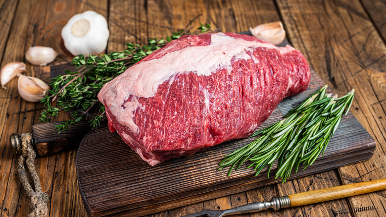 raw beef brisket on wooden board