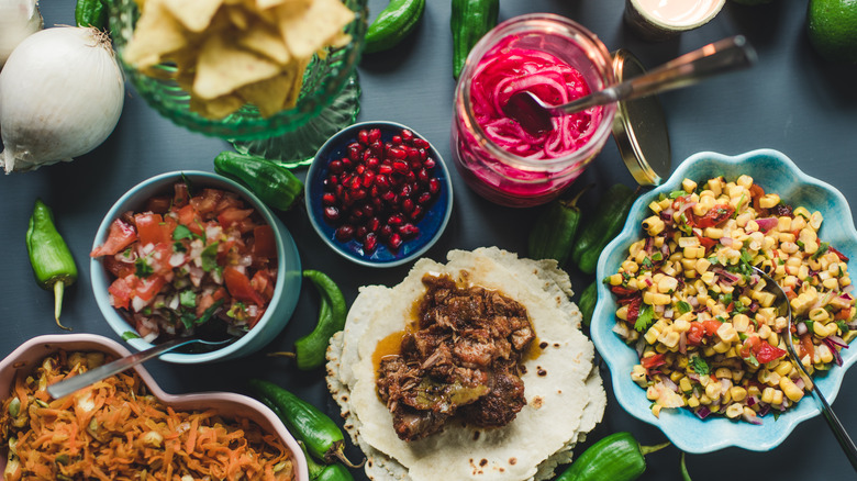 Taco spread with pickled red onions, corn salad, and pico