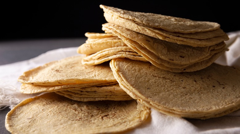 Corn tortillas piled on a white cloth