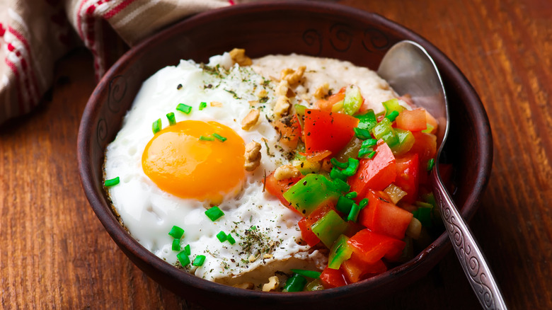 savory oatmeal in bowl with egg and peppers